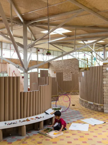 These images showcase the interior of the Atelier school, where partitions are made from recycled paper tubes. This innovative material choice is not only sustainable but also creates a playful, maze-like environment that encourages exploration and imaginative play.