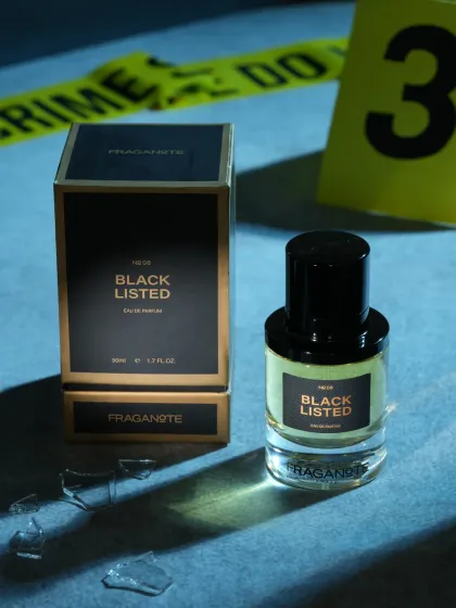 A conceptual shot for a perfume named 'Black Listed', using crime scene tape and broken glass. This kind of creative storytelling makes a product memorable and intriguing.