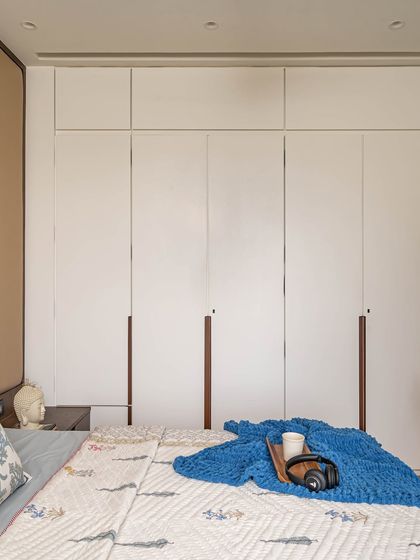 A view of the floor-to-ceiling white cupboards in the kids' room, which offer extensive storage. The clean design helps maintain a practical and organized space for play and rest.