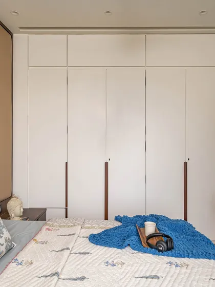 A view of the floor-to-ceiling white cupboards in the kids' room, which offer extensive storage. The clean design helps maintain a practical and organized space for play and rest.