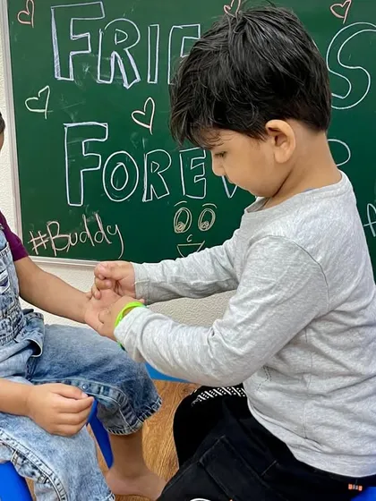 A helping hand for a friend. Our Friendship Day celebration was filled with moments of kindness and cooperation as children shared bands and smiles.