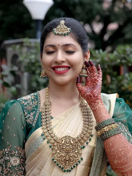 A bride’s smile is my greatest reward. This bride chose an elegant off-white Kanjeevaram silk saree with a rich emerald green border and a matching embroidered puff-sleeve blouse, proving that you don't need red to be a classic bride.