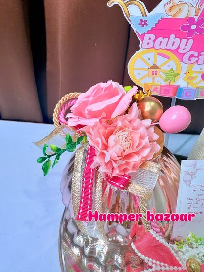 A close-up of the floral details and ribbons on our pink baby girl hamper.