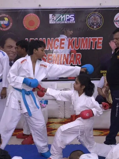 Learning from the masters is key. In this shot from our Advanced Kumite Seminar, legendary instructor Hanshi Bharat Sharma personally observes and guides young students during a sparring session, ensuring proper form and technique.