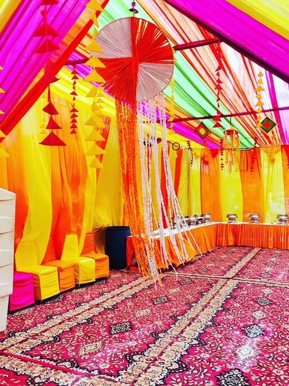 A colourful tent interior with hanging decorative elements, perfect for a lively Haldi or Mehendi function.