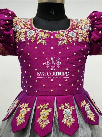 This close-up shows the detailed floral maggam work and pearl accents on a magenta blouse, set against puff sleeves with a Banarasi border.
