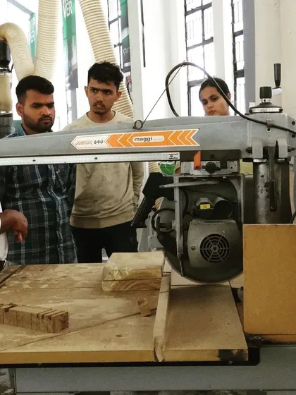 Students learn about the radial arm saw, a key piece of equipment for making precise crosscuts in woodworking projects.