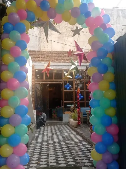 A large and welcoming pastel-colored balloon arch for the entrance of a cafe or shop. This is perfect for openings, anniversaries, or special events.