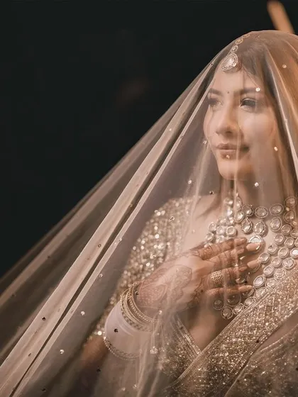 An ethereal bridal portrait, with the veil creating a soft, dreamy focus on the bride's serene expression. We specialize in capturing the quiet moments of anticipation and grace before the ceremony.