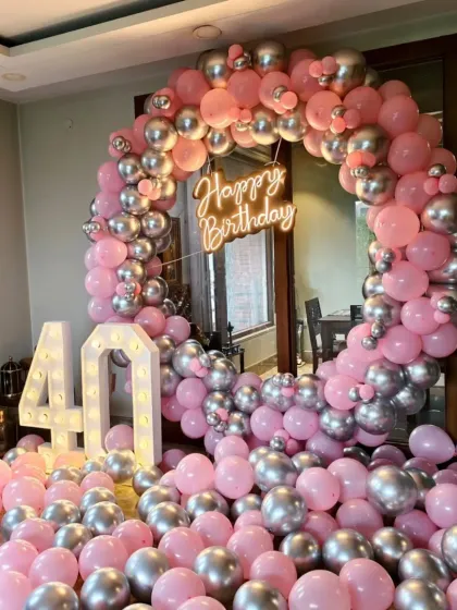 A wider angle of the 40th birthday setup, showing the marquee numbers and balloons on the floor.