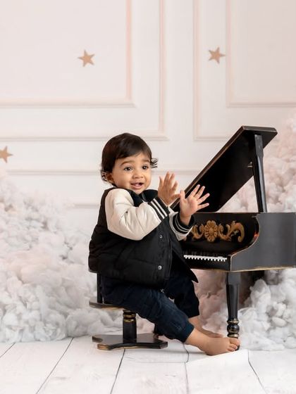 A modern and elegant setup featuring a toddler at a miniature piano, surrounded by dreamy clouds and stars.