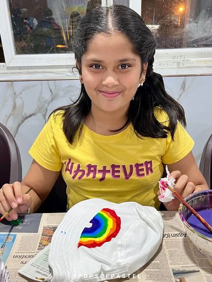 This young artist is happy with her rainbow creation, a perfect accessory she made herself.