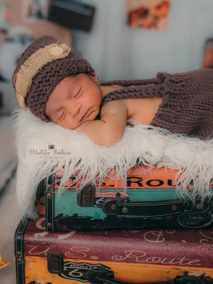Dreaming of distant lands. This little traveler is so content in his cozy, knitted outfit, making for the most precious newborn photos.