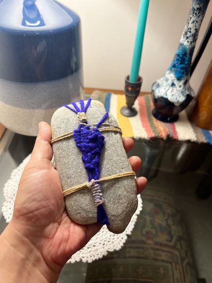 The back of the wrapped pebble reveals the knotting and finishing techniques used to secure the weave. Every part of the object is considered, making the final piece a complete little work of art from all angles.