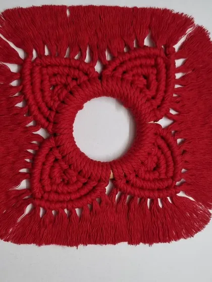 The red diya holder without the candle, showcasing the intricate knotwork and central opening.