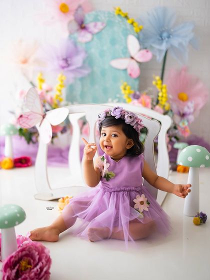 A playful moment on the floor of the magic garden, pointing up at something that has caught her eye.