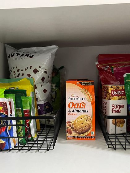 Using simple wire baskets is an effective way to organize snacks and other packaged goods. This keeps items contained and prevents them from toppling over on the shelf.