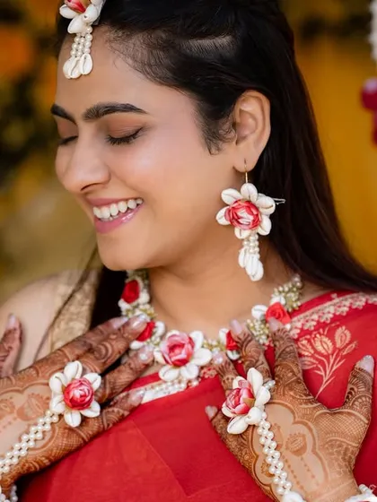 A close-up of the bride's radiant smile and her delicate floral jewelry, a popular choice for modern Haldi functions.