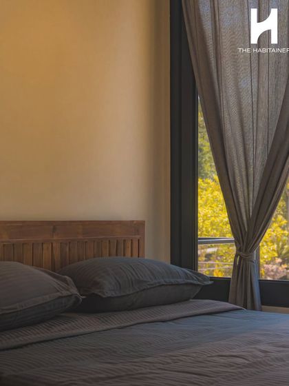 A close-up of the bedroom shows the simple, clean design with a wooden headboard and soft, neutral tones, creating a calm and restful atmosphere.