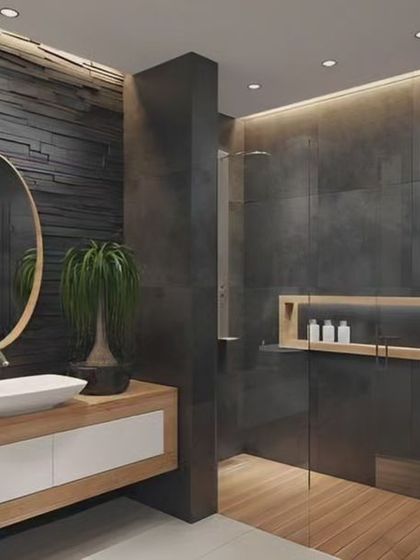 A rustic-modern bathroom with a stacked stone accent wall. The floating wood vanity and vessel sink add a natural, organic touch to the space.