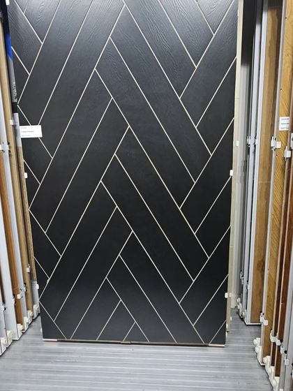 A bold, black wood-look tile with white grain lines laid in a herringbone pattern. This is a modern, high-contrast flooring option that makes a dramatic statement.