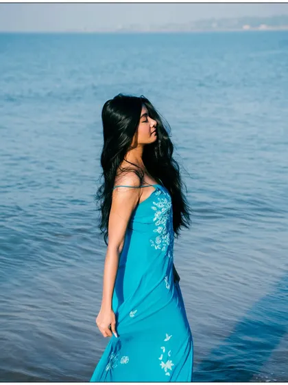 A serene and peaceful portrait with the model standing in the calm sea. The soft light and gentle waves create a tranquil mood.