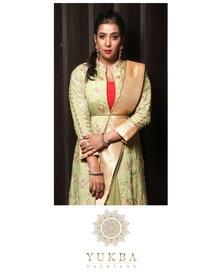 A close-up portrait of the model in the pistachio green gown, showing the neckline and the attached drape.