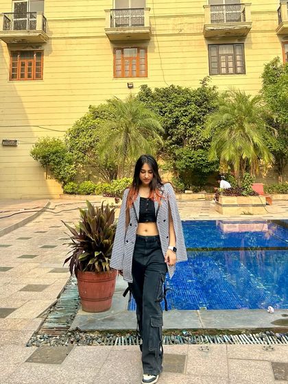 A chic poolside look with a blazer worn as a cape over a crop top and cargo pants. This shows my ability to create fashion-forward, layered looks.
