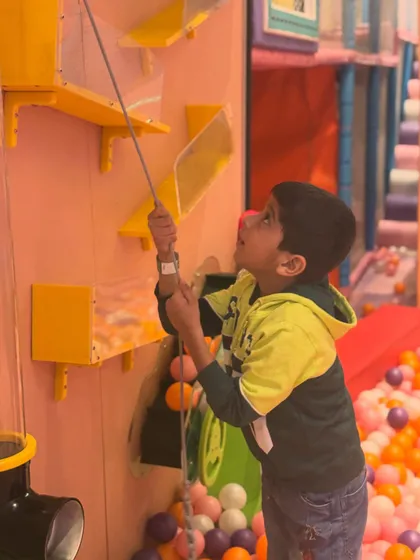 Trying out the interactive ball wall. Kids can use pulleys and levers to move balls around, making it a fun and engaging STEM activity.