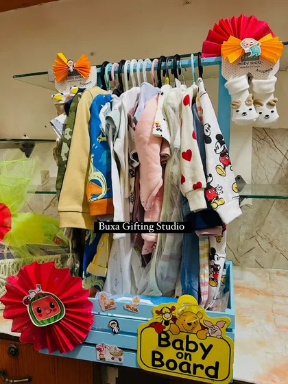 This baby wardrobe hamper is a creative and practical gift, displaying tiny clothes on hangers with fun "Baby on Board" and Cocomelon details.