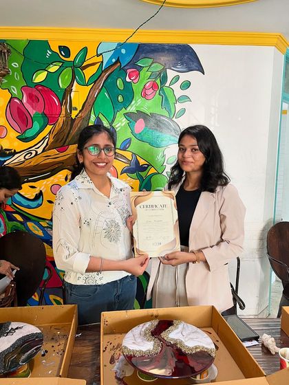 Happy faces from a successful Resin Art workshop. Here, a participant receives her certificate of completion in front of her beautiful geode-style clock.