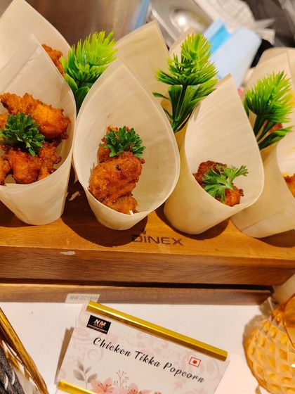 Chicken Tikka Popcorn is one of our most playful creations. These bite-sized chicken pieces are packed with tandoori flavor and served in individual paper cones for a fun, easy-to-eat snack.