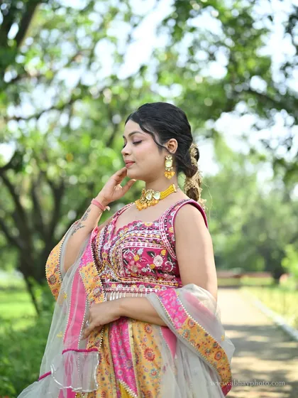 A close-up of the pink and yellow patchwork lehenga's blouse, showing the intricate floral embroidery and beadwork.