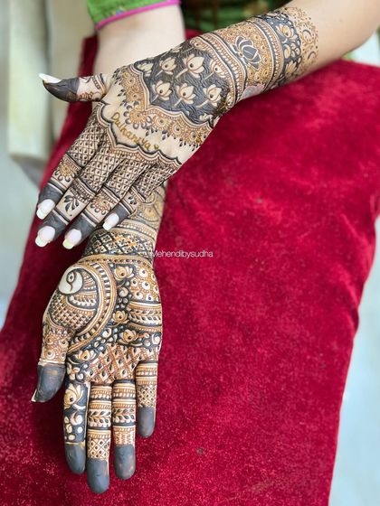 A creative pose showing the contrast between the front and back of the hands in this semi-bridal peacock design.