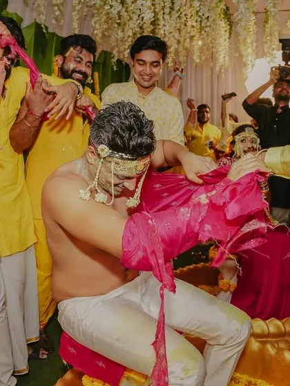 The hilarious and chaotic 'kurta-faad' Haldi tradition, capturing the groom being playfully mobbed by his friends.