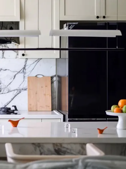 A closer view of the kitchen, highlighting the beautiful Statuario marble backsplash and the sleek, modern appliances. The design is both highly functional and aesthetically pleasing.