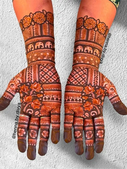 A symmetrical design filled with traditional Indian patterns. The arms feature bands of elephants, while the palms have a mix of lotus and geometric grid work.