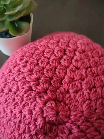 A top-down view of the Flora beanie, showing the neat circular increases that create the crown of the hat. This is a fundamental technique for making any top-down beanie.