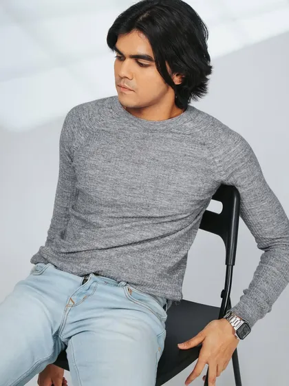 A casual, seated portrait for a male model's portfolio. The lighting creates a nice shadow effect from the window.
