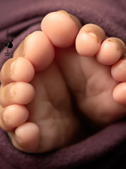 The tiniest details are often the most precious. I always make sure to capture close-ups of a newborn's perfect little feet, a detail you'll want to remember forever.