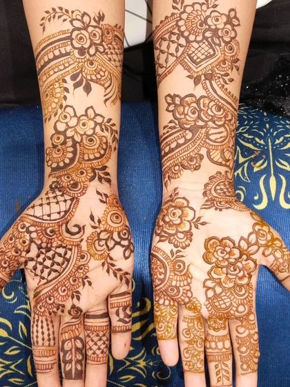 A designer floral mehendi with a mix of bold flowers, delicate vines, and intricate netting. This style is perfect for someone who wants a unique and modern take on traditional henna.
