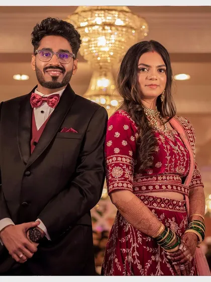 The stunning couple at their reception. Aditi's makeup is classic and elegant, complementing her partner's sharp tuxedo.