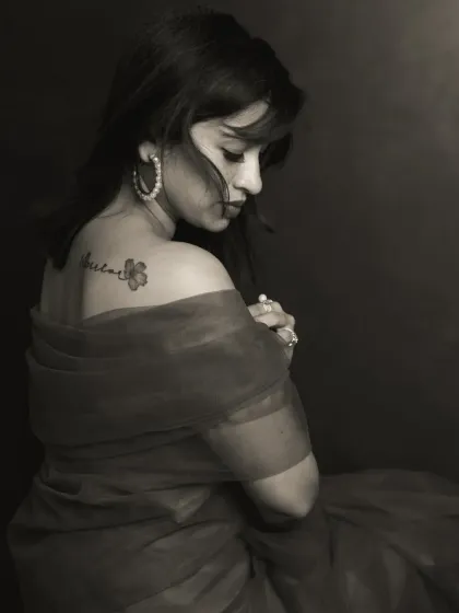 There is a unique power in monochrome. By stripping away color, we focus on the raw emotion, the subtle play of light on skin, and the story told in a single glance. This portrait captures a moment of quiet introspection, highlighting the delicate tattoo as a personal mark of her journey.