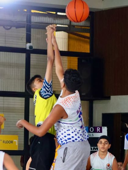 A contested shot under the basket during a sub-junior game. Our players learn to be aggressive and confident even when facing tough defense.