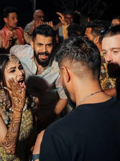 The best moments are the candid ones. Here's the bride, Mouni Roy, and her friends reacting to a track drop during her Mehendi party. It's my job to create these moments of pure joy.