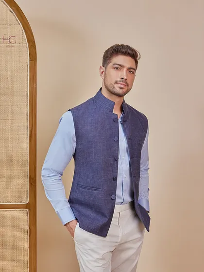 A modern twist on a classic style. This navy bundi paired with a light blue shirt and cream trousers is a versatile and sophisticated look for any wedding guest.