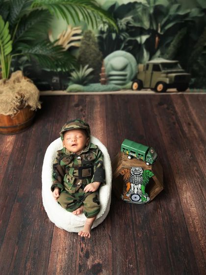 A wider shot of the patriotic theme, with the baby sleeping soundly next to the Indian national emblem.