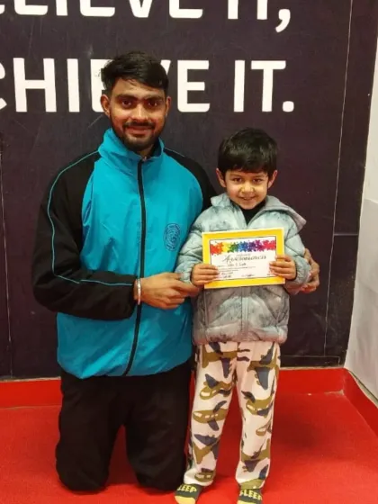 This young boy is proud to show off the certificate he earned for his hard work.