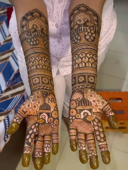 A stunning design filled with peacocks and swans. The couple's initials, "NR", are hidden within the intricate patterns on the palms, making for a fun game for the groom.
