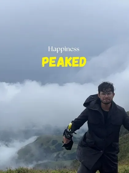 A happy trekker against the backdrop of misty peaks, with the caption "Happiness PEAKED".
